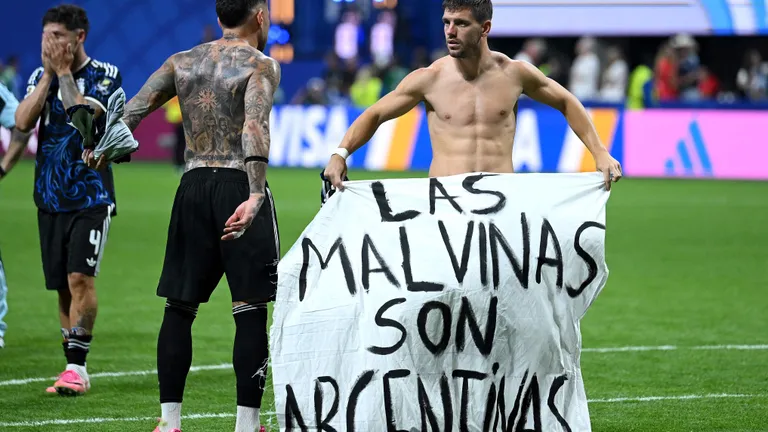 ATLANTA, GEORGIA - JULY 15: Giovani Lo Celso #11 of Argentina holds a banner after the 2-1 win during the FIFA World Cup 2026 Semi Final match between England and Argentina at Atlanta Stadium on July 15, 2026 in Atlanta, Georgia. The banner refers to the British Overseas Territory of the Falkland Islands, located off the coast of Argentina. Argentina disputes British sovereignty over the islands and refers to them as Las Malvinas. Shaun Botterill/Getty Images/AFP (Photo by Shaun Botterill / GETTY IMAGES NORTH AMERICA / Getty Images via AFP)