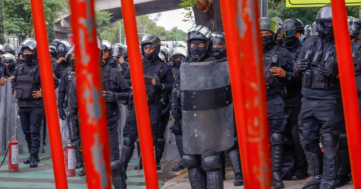 Members of the police block the way to the Ciudad de Mexico Stadium during a protest in Mexico City on June 9, 2026. Thousands of teachers blocked an avenue leading to the Azteca Stadium in Mexico City, 48 hours before the opening ceremony of the 2026 World Cup at that venue. (Photo by Gerardo Magallon / AFP)