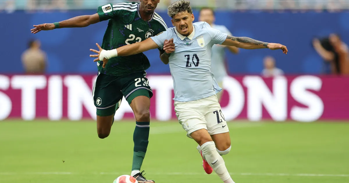 TOPSHOT - Saudi Arabia's midfielder #23 Mohamed Kanno and Uruguay's midfielder #20 Maximiliano Araujo fight for the ball during the 2026 World Cup Group H football match between Saudi Arabia and Uruguay at the Miami Stadium in Miami Gardens on June 15, 2026. (Photo by PATRICIA DE MELO MOREIRA / AFP)