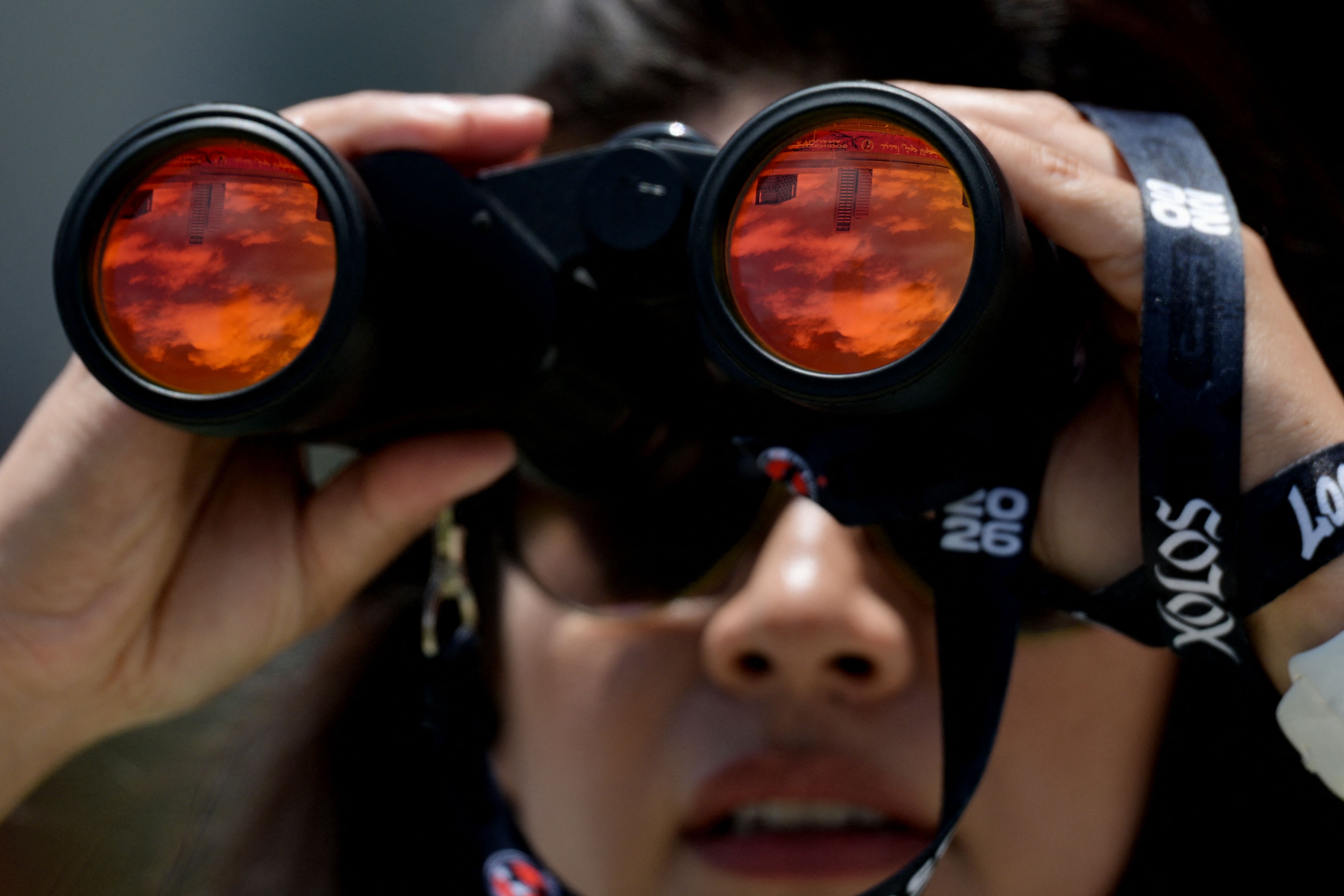 A security guard watches with her binoculars during a training session of Iranian players ahead of Iran's FIFA World Cup 2026 Group G football match against Belgium at Centro Xoloitzcuintle in Tijuana on June 18, 2026. (Photo by Guillermo Arias / AFP)