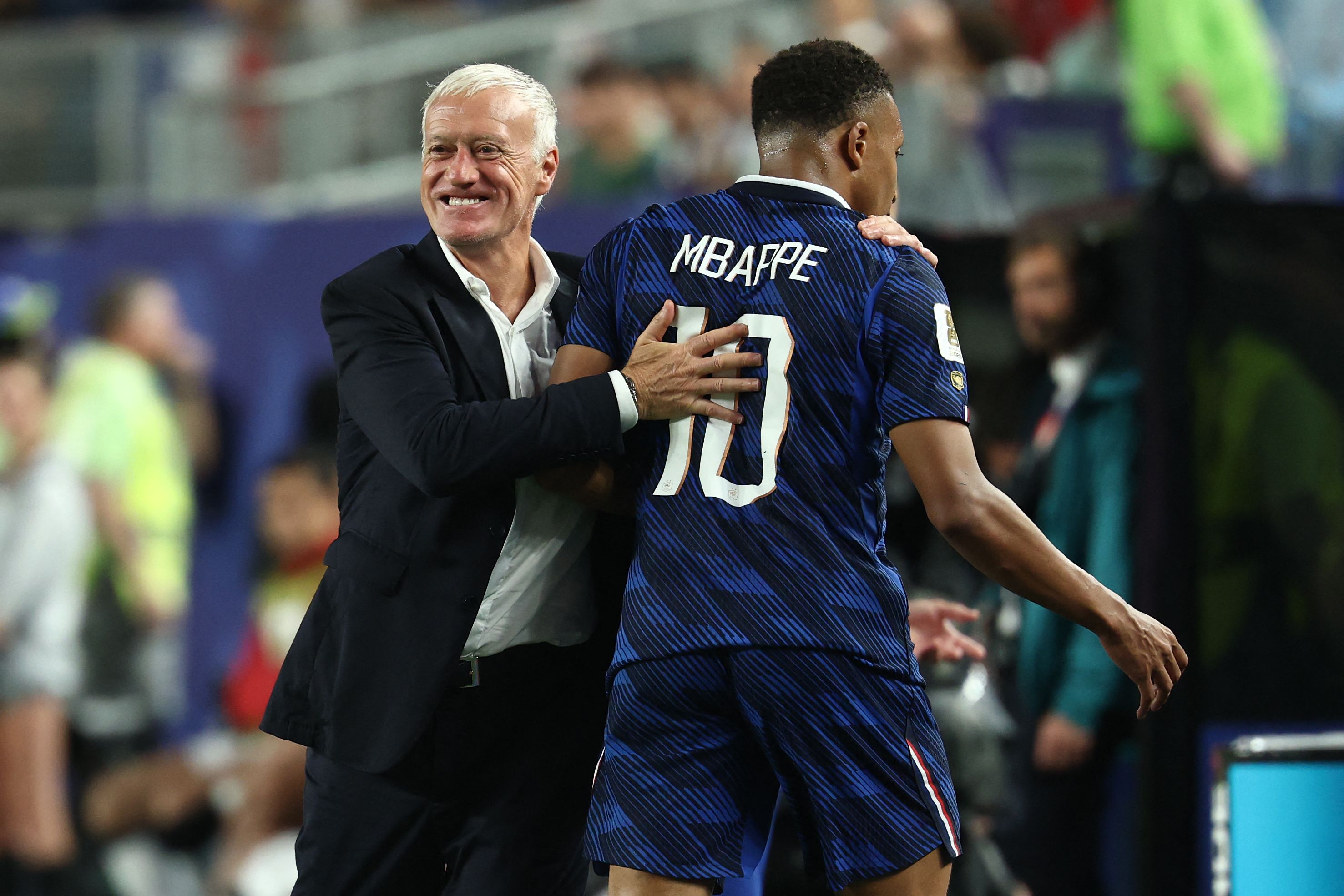 TOPSHOT - France's forward #10 Kylian Mbappe hugs head coach Didier Deschamps after being substituted during the 2026 World Cup Group I football match between France and Iraq at the Philadelphia Stadium in Philadelphia on June 22, 2026. (Photo by FRANCK FIFE / AFP)
