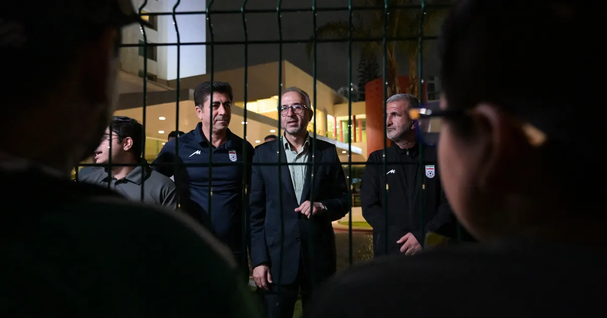 Iran's ambassador to Mexico Abolfazl Pasandideh (C) and Football Federation of Iran (FFIRI) secretary general Hedayat Mombeini (2nd L) speak to supporters and media representatives after Iran's elimination from the 2026 FIFA World Cup football tournament at the Marriott Hotel in Tijuana, Mexico, on June 27, 2026. (Photo by Guillermo Arias / AFP)