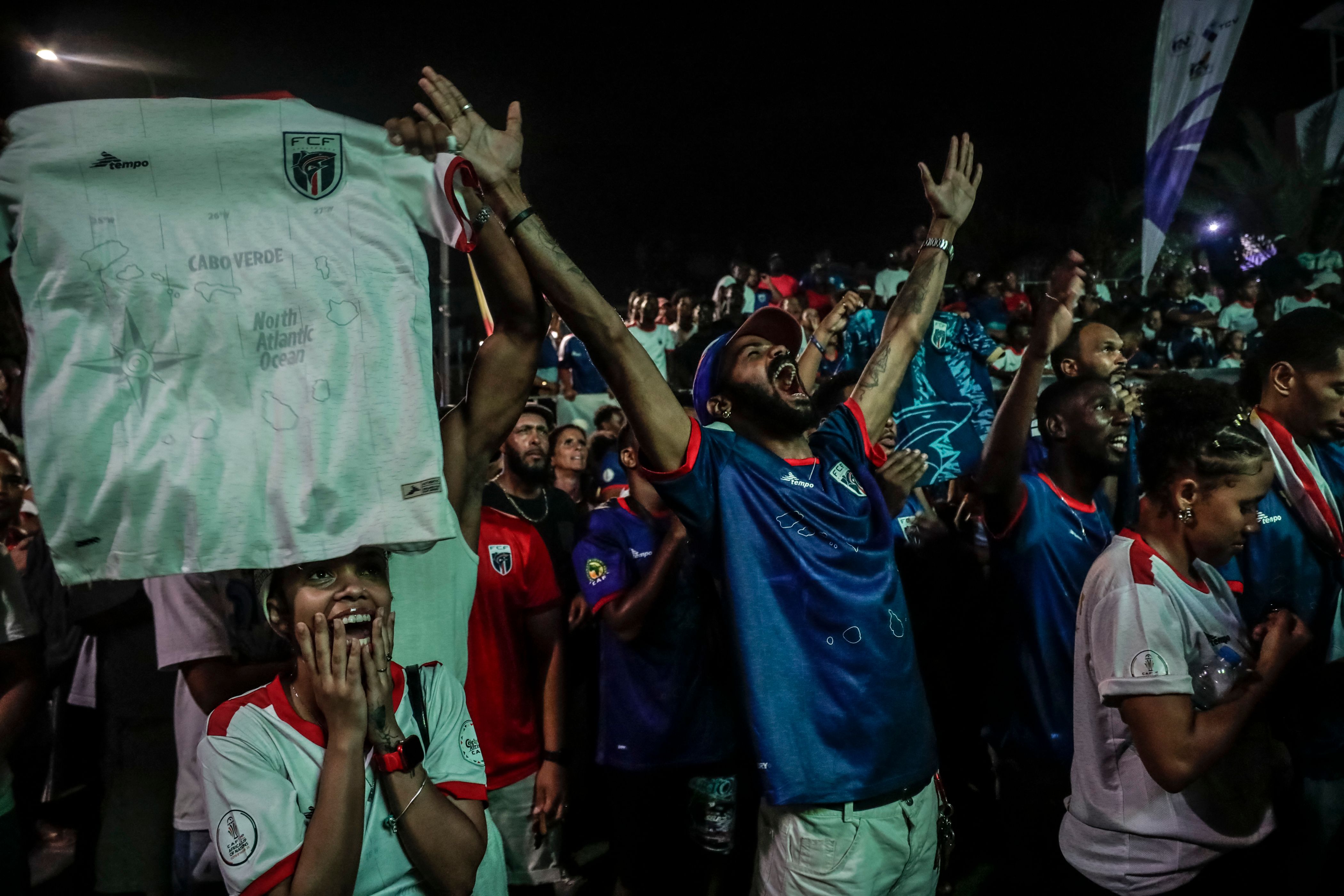 TOPSHOT - Supporters of Cape Verdes national football team celebrate Cape Verdes second goal during the 2026 World Cup round of 32 football match between Argentina and Cape Verde in Praia on July 3, 2026. (Photo by Jose Correia / AFP)