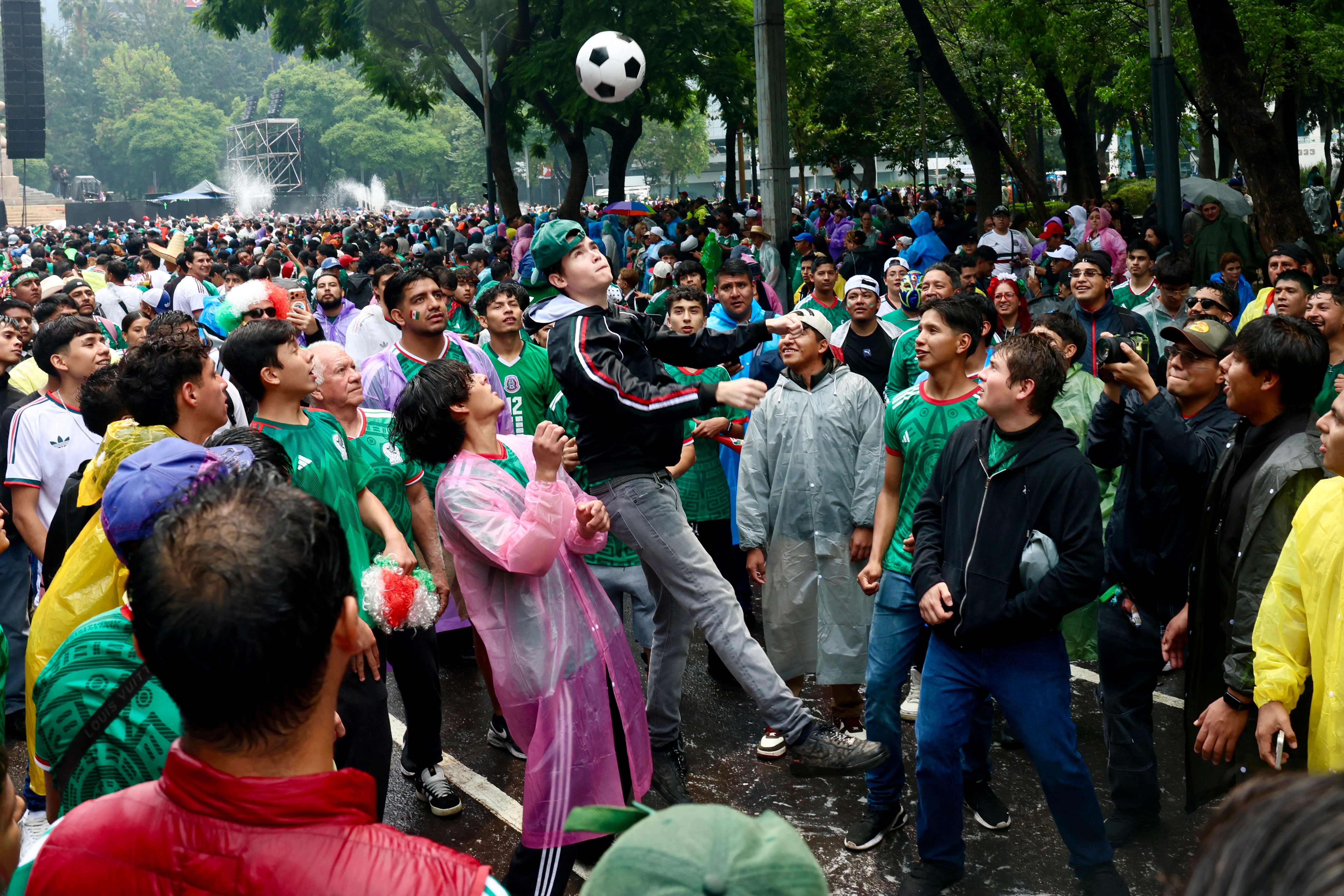 Mexican football fans play with a ball as they gather at the Angel of Independence to watch the 2026 FIFA World Cup Round of 16 football match between Mexico and England in Mexico City on July 5, 2026. (Photo by Claudia Rosel / AFP)