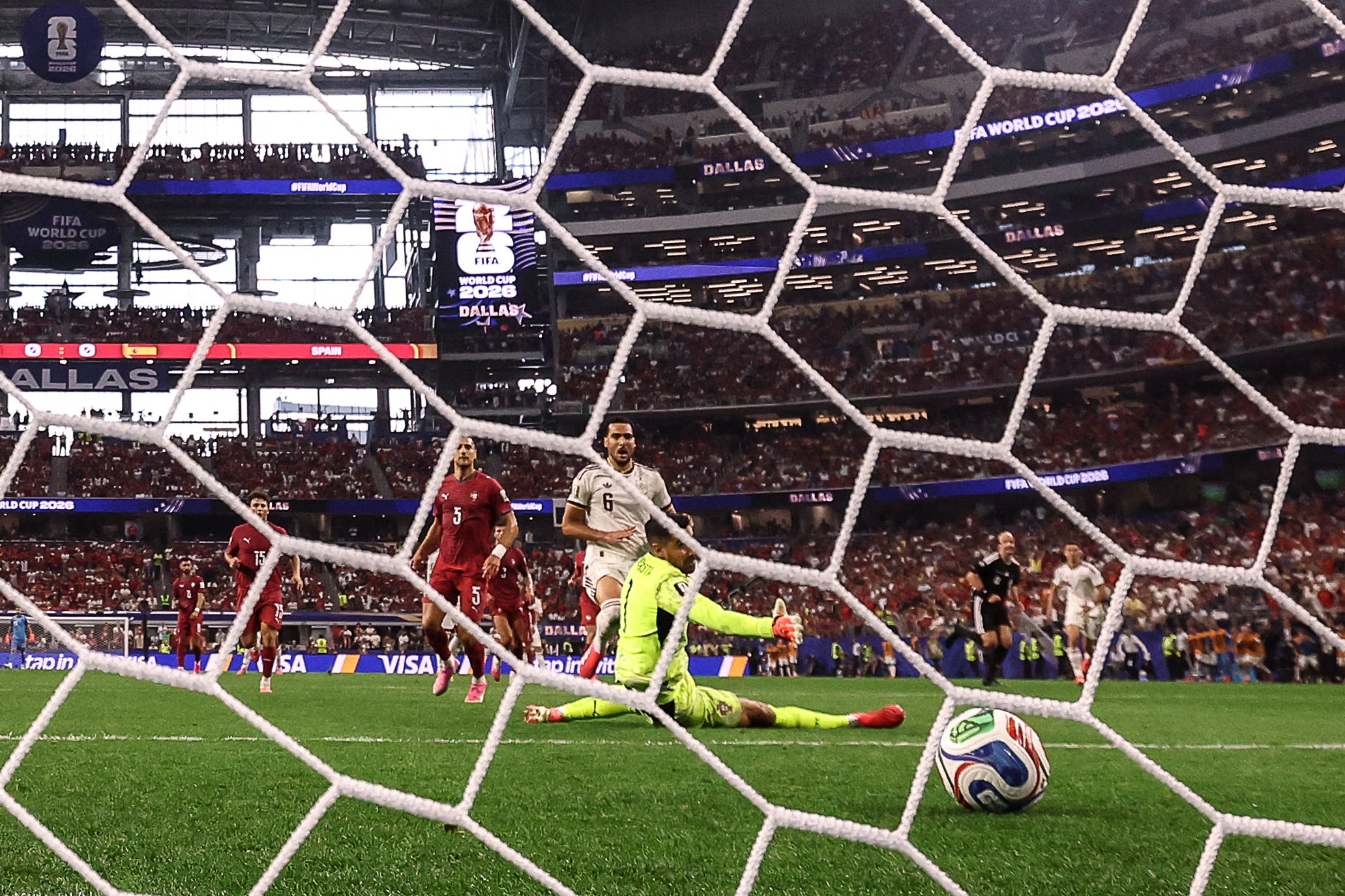 Spain's midfielder #06 Mikel Merino scores his team's first goal past Portugal's goalkeeper #01 Diogo Costa during the 2026 World Cup round of 16 football match between Portugal and Spain at the Dallas Stadium in Arlington on July 6, 2026. (Photo by Thomas COEX / AFP)