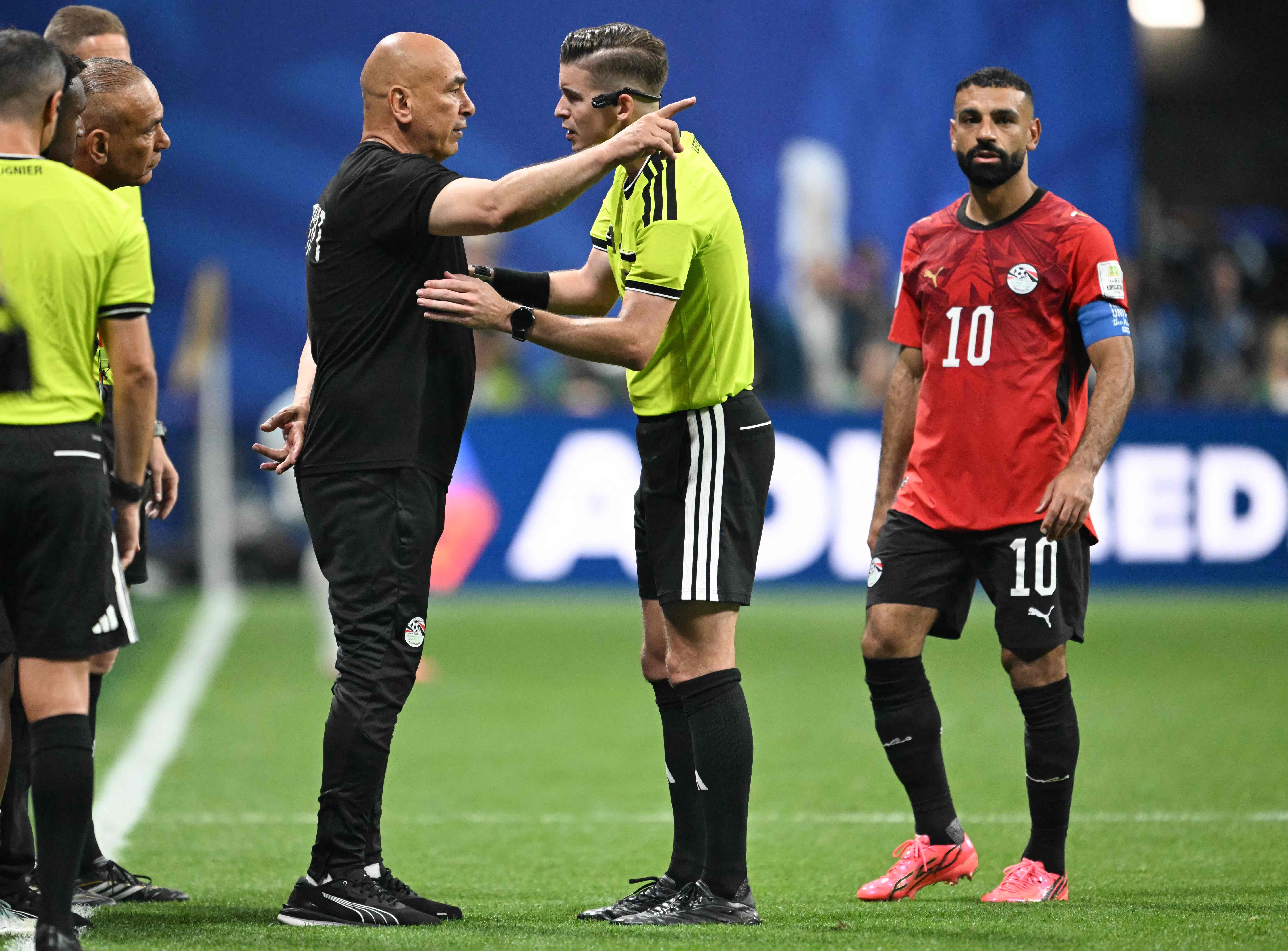 Egypt's head coach Hossam Hassan speaks with French referee Francois Letexier as Egypt's forward #10 Mohamed Salah looks on during the 2026 World Cup round of 16 football match between Argentina and Egypt at Atlanta Stadium in Atlanta on July 7, 2026. (Photo by ROBERTO SCHMIDT / AFP)