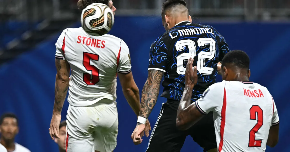 Argentina's forward #22 Lautaro Martinez (C) scores his team's second goal past England's defender #05 John Stones (L) and England's defender #02 Ezri Konsa during the 2026 World Cup football tournament semi-final match between England and Argentina at the Atlanta Stadium in Atlanta on July 15, 2026. (Photo by Paul ELLIS / AFP)