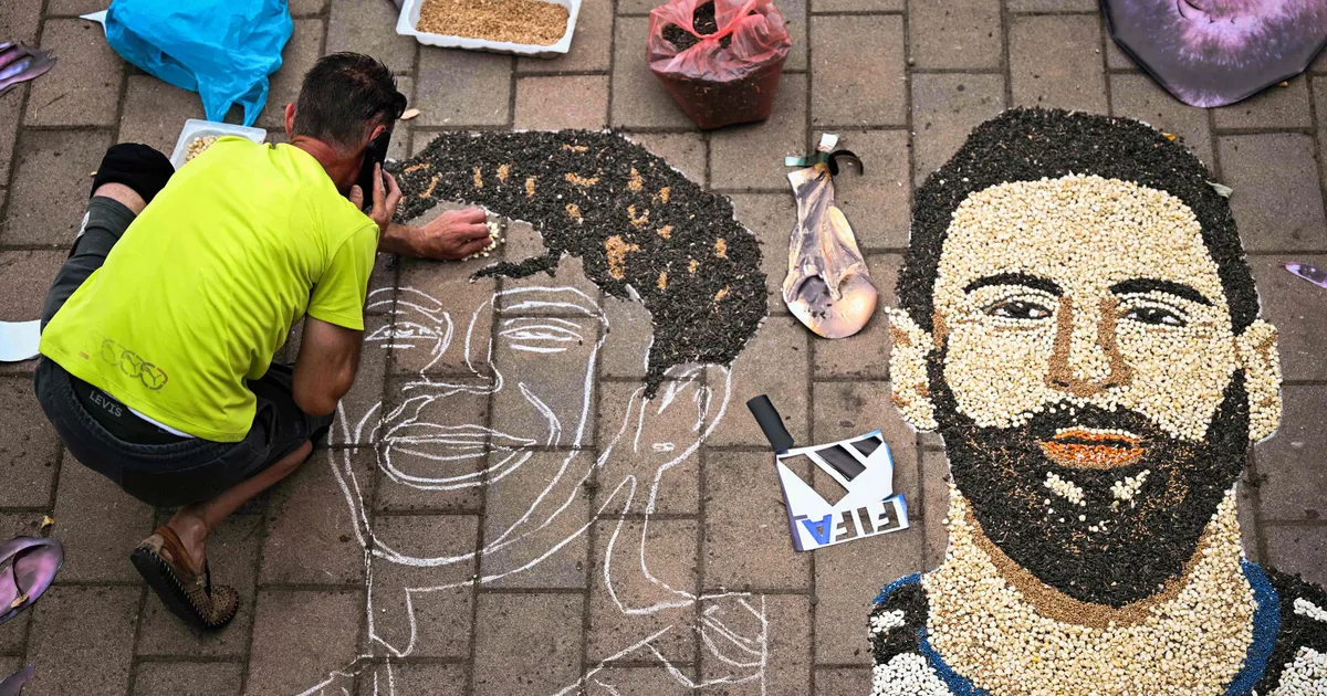 Kosovar artist Alkent Pozhegu works on a mosaic on the ground, made with grain and seeds, and depicting Argentina's forward #10 Lionel Messi (R) and Spain's forward #19 Lamine Yamal, in the town of Gjakova on July 16, 2026. Thousands of kilometres away from New York, where the Argentina and Spain football teams will compete for the World Cup title, in the western city of Gjakova, Alkent Pozhegu has made a mosaic depicting the two forward stars Lionel Messi and Lamine Yamal. (Photo by Armend NIMANI / AFP) / RESTRICTED TO EDITORIAL USE - MANDATORY MENTION OF THE ARTIST UPON PUBLICATION - TO ILLUSTRATE THE EVENT AS SPECIFIED IN THE CAPTION