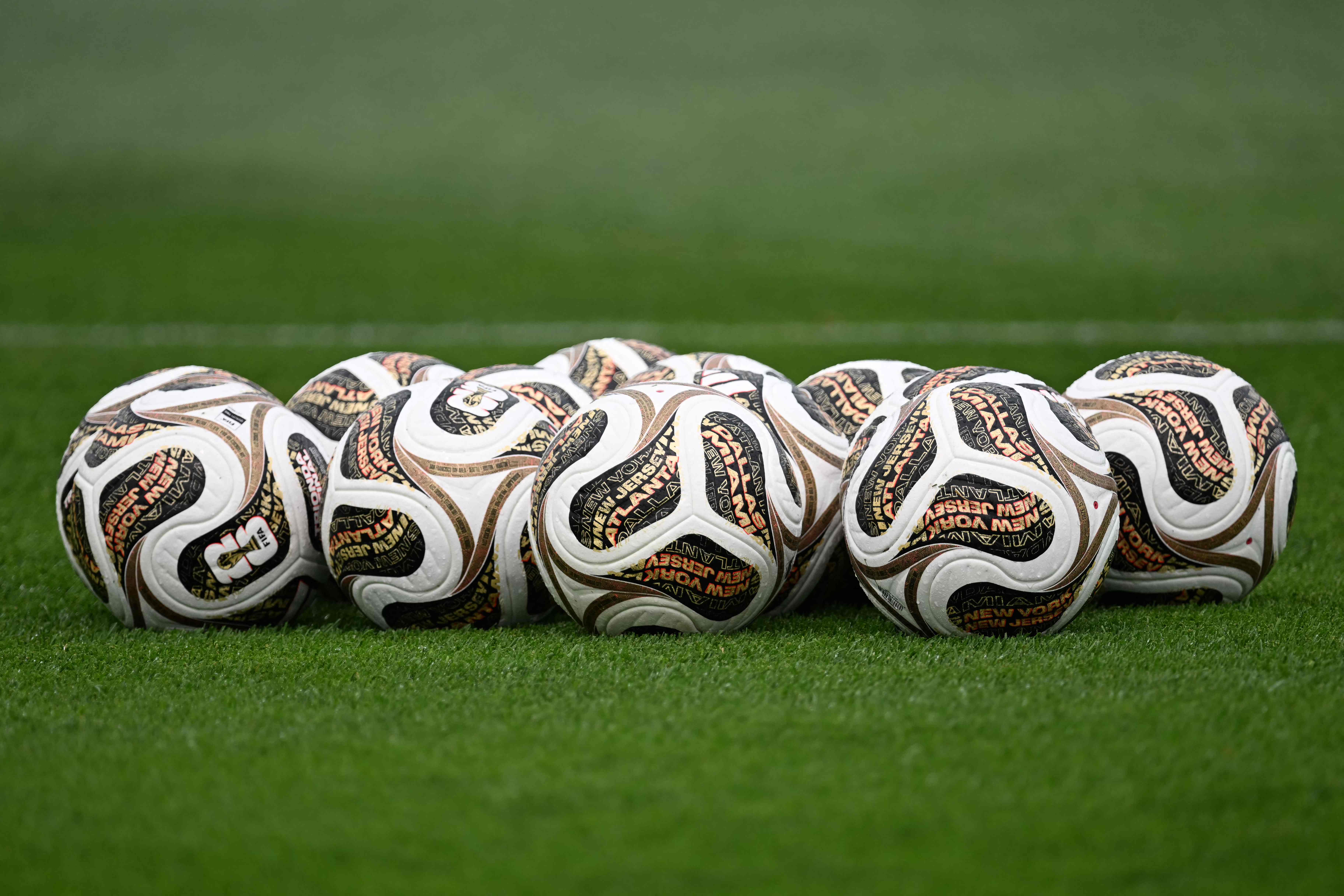 A photo shows official competition balls for the final stages on the pitch during a Spain training session at Melanie Lane Training Grounds in East Hanover, New Jersey, on July 16, 2026, ahead of the 2026 World Cup football tournament final match between Spain and Argentina. (Photo by MAURO PIMENTEL / AFP)
