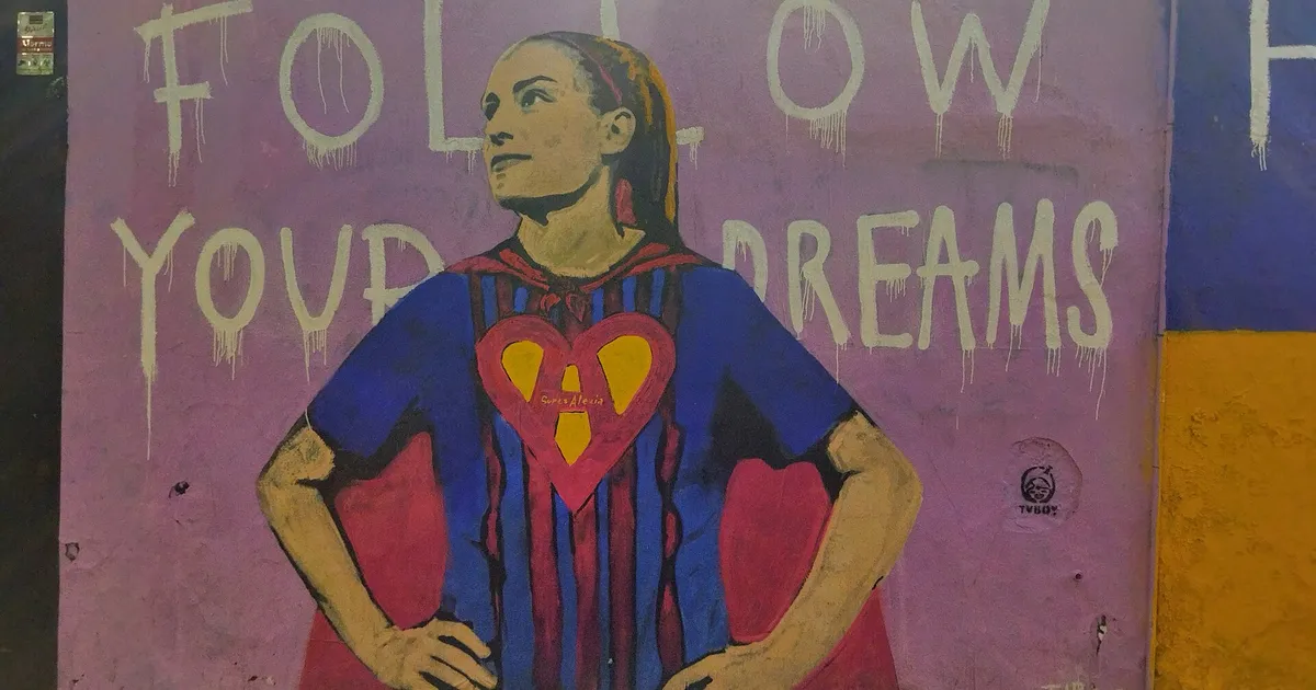 The mural shows soccer player Alexia Putellas Segura. Behind the image of her, the following phrase in English is shown: "Follow your dreams". The player wears a Barcelona Football Club shirt and a superwoman cape, on the shirt as a shield the letter "A" is printed, which represents the player's name. The mural is located in the Gracia neighborhood of Barcelona.