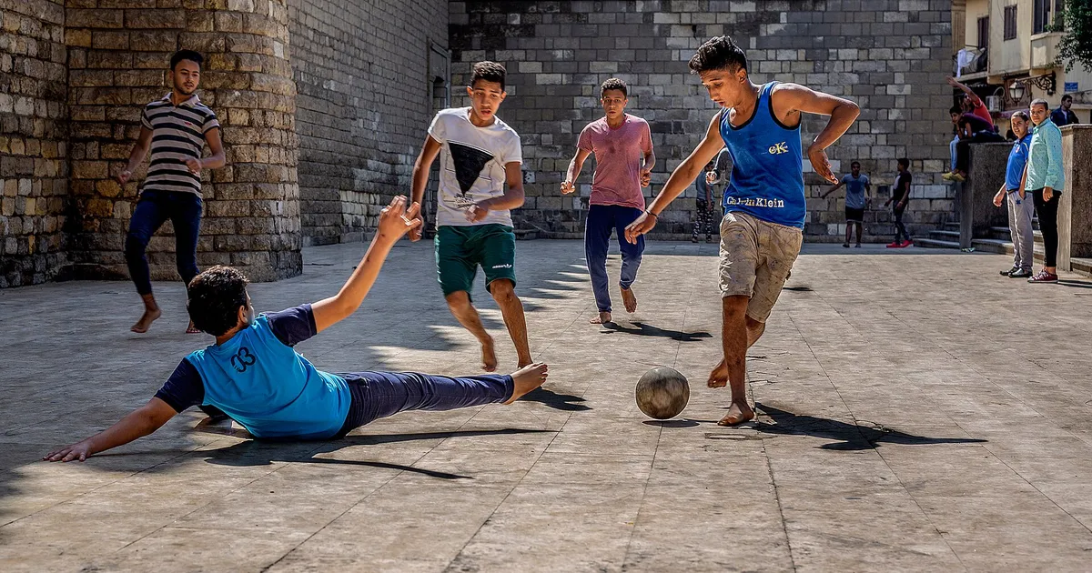 Children playing street football in Egypt, one of the most famous games in Africa. Location: Al-Mu'izz Street, at the exterior of Al-Hakim mosque - Camera location 30° 03′ 17.49″ N, 31° 15′ 47.37″ E View this and other nearby images on: OpenStreetMap 30.054859; 31.263158