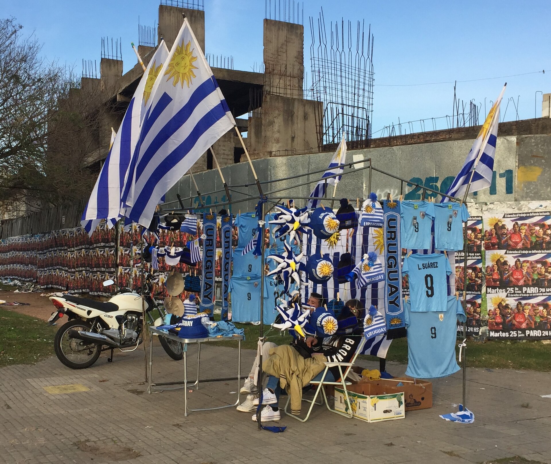 Durante la Copa América 2019 de Brasil, un vendedor callejero ofrece banderas uruguayas, camisetas de la selección celeste y otros artículos para la hinchada, en la esquina de Br. Artigas y Av. Millán, Montevideo.